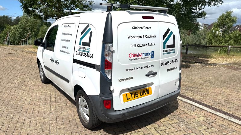 The back of the white Kitchens MK van, showing the logo, the phone number 01908 384404 and the words Kitchen Doors, Worktops and Cabinets, Full Kitchen Refits