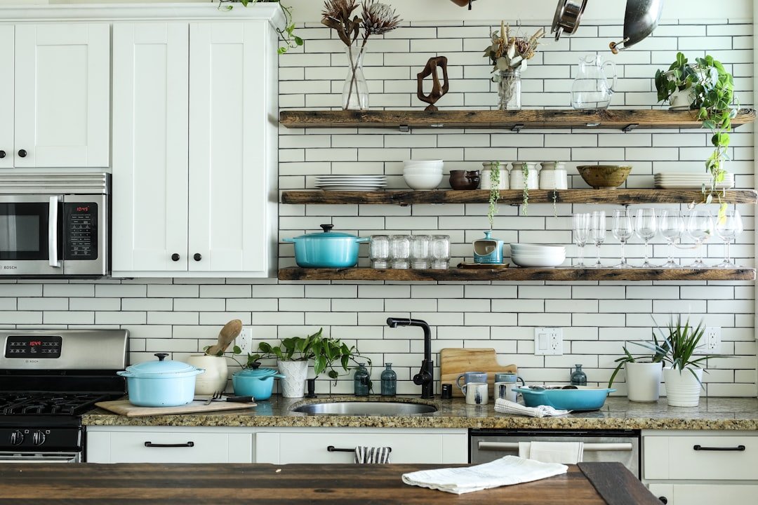 Open wooden shelves on white metro tiles above a speckled worktop
